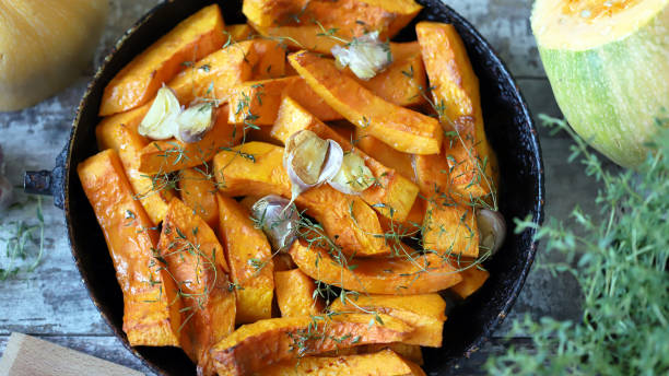 istock Pumpkin slices with thyme and garlic in a pan. 1284749624