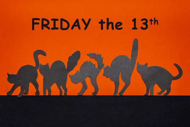 Happy Friday the 13. Black funny wild cat silhouettes on orange and black background. Day of bad luck, failure, horror concept. Text FRIDAY THE 13TH.