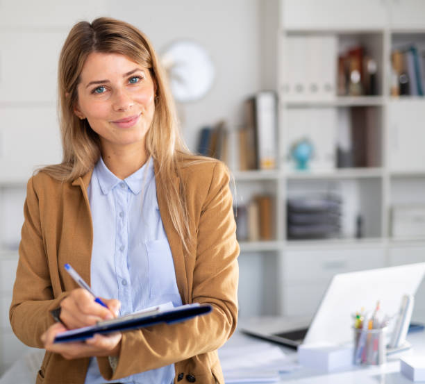 istock positive female manager with docs working in white room 1284752129