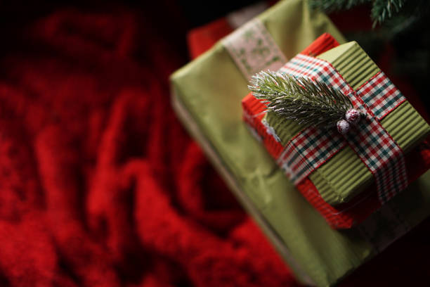 istock Beautiful Christmas green gift boxes under the Christmas tree on red blanket 1284752260