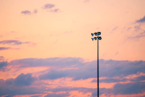Single pole or column of spotlight or stadium light in arena with sunset beautiful sky and with copy space.