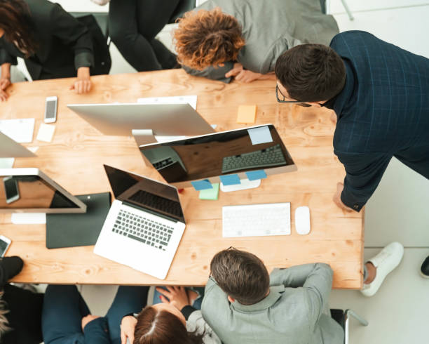 istock top view. business team sitting at Desk and looking at blank screen 1284752650
