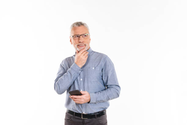 istock Pensive smiling man holding smartphone and thinking isolated 1284755920