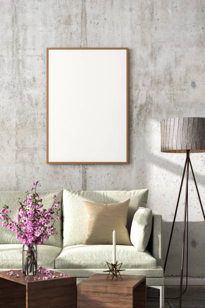 istock Interior scene: living room mockup with a sofa in a loft style building. One empty picture frame (70x100cm). Concrete wall, floor lamp, coffee tables, cherry blossoms. 3d render 1284757799