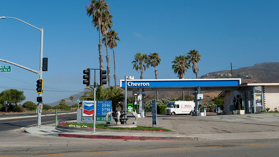 July 13, 2020 - Malibu, California. Chevron gas station exterior with fuel at $3.59, Malibu, California. Palm trees line the road along Highway 1 and Tancas Canyon Road