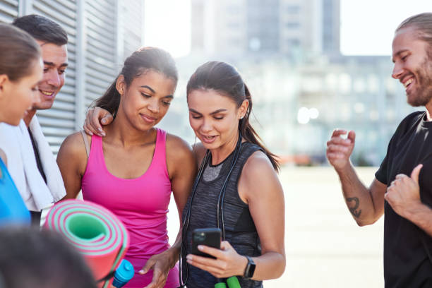 istock Young multiracial sportive friends watching at smartphone 1284760149
