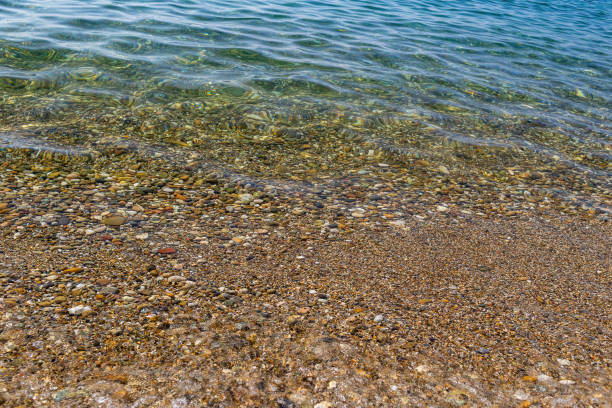istock Calm clear sea on a pebble beach 1284760385