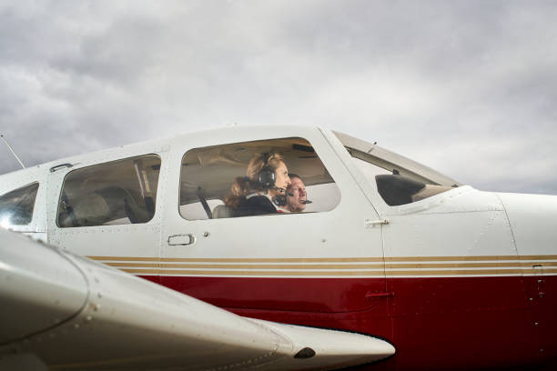 Female flight instructor with her student Plane in flight. Female flight instructor giving flight lessons to a student. ultralight stock pictures, royalty-free photos & images
