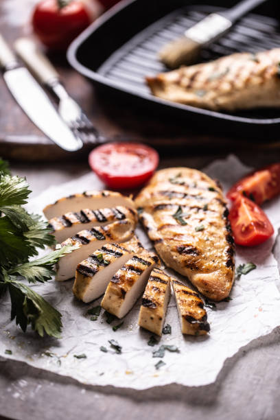 istock Chicken breast slices grilled on paper with celery herbs and tomatoes 1284761952