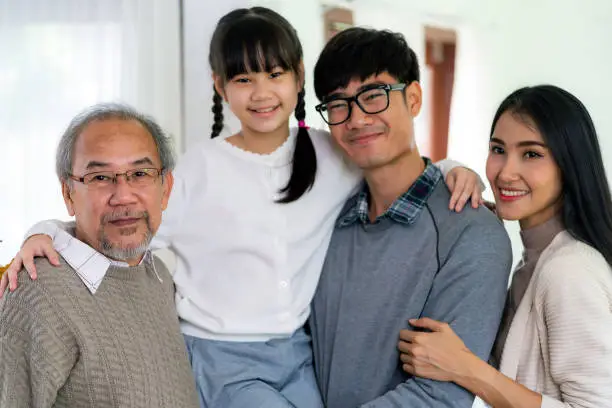 Group Portrait of Happy multigenerational asian family standing in living room with smile in new apartment. Muti generation family happiness concept.
