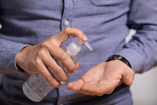 istock Man applying disinfectant alcohol gel on hands 1284762337