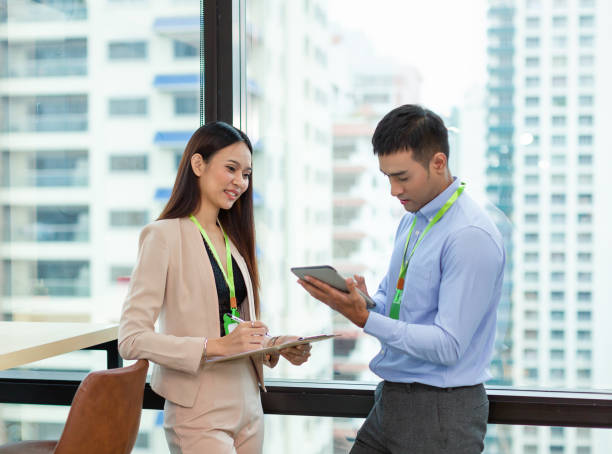 istock Asian businessman and businesswoman explaining work with paper chart and digital tablet. Group of Asian businesspeople talking ideas new project in the modern office. businesspeople and office concept 1284763633