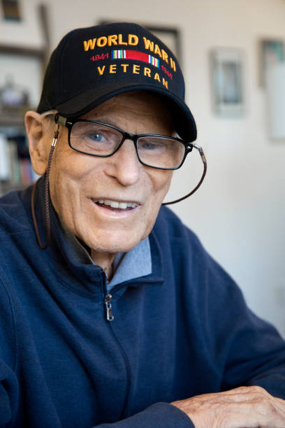 istock World War Two Veteran wearing cap sitting at home smiling looking at camera 1284763755