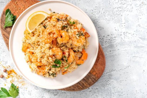 istock Couscous with fried shrimps, tomatoes, onions, and herbs 1284764946