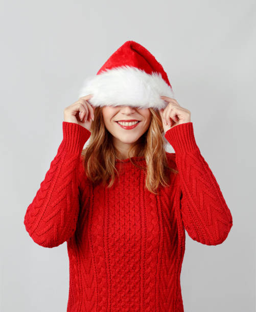 istock Young woman covering her eyes while touching santa hat 1284764969