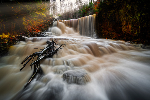 Waterfall in dusk photographed with long exposure to get a tranquil dreamy image,
