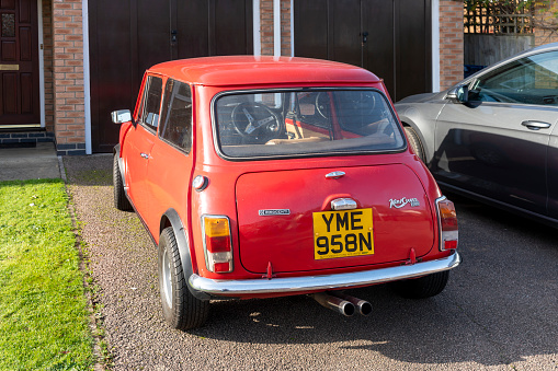 This is a 1974 Classic Mini Cooper Innocenti 1300 Export.  This is a rear view of the whole car on the owners drive.