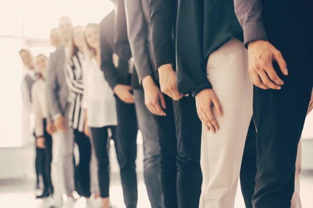 image of young business people standing in a long queue stock photo