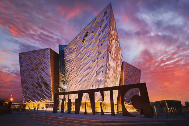 Sunset over Belfast Titanic, Belfast, Northern Ireland, UK Belfast, Northern, Ireland - June 28, 2017: Sunset over Titanic Belfast - museum, touristic attraction and monument to Belfast's maritime heritage on the site of the former Harland and Wolff shipyard. experiential travel stock pictures, royalty-free photos & images