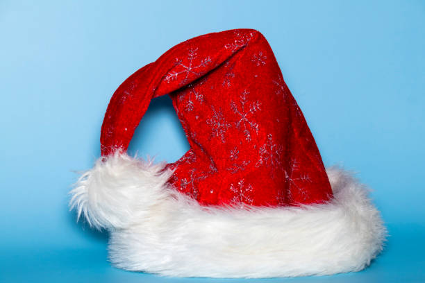 istock Red and white santa hat shot on a blue background 1284768471