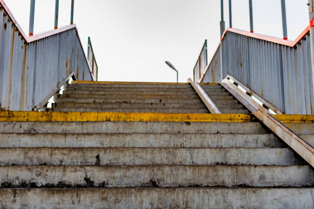 istock Dirty, trampled concrete steps with metal railings on each side. Old built structure for walking. Ascent and descent 1284769820