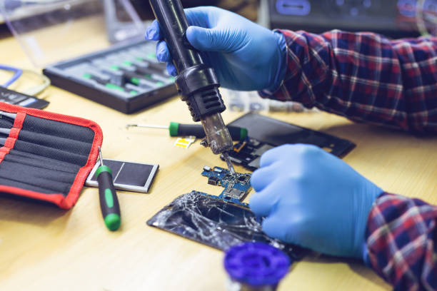 istock Technician Worker Soldering Elements and Repairing Smart Phone 1284770352