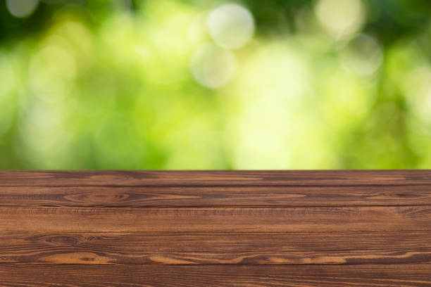 istock wooden empty table with blurred green garden 1284773536