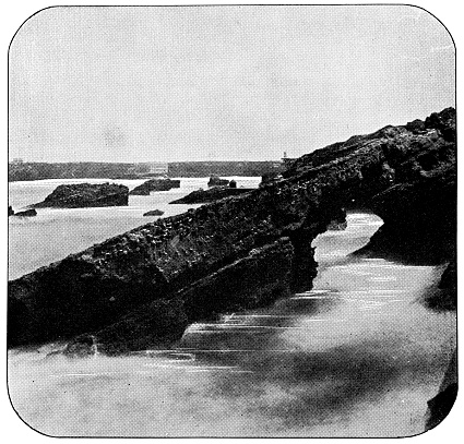 Rock formations in the Bay of Biscay along the coast of Biarritz, France. Vintage half tone photo etching circa 19th century.