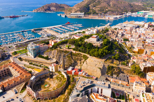 Aerial view of Cartagena port city with buildings and coast line, Murcia Aerial view of Cartagena port city with buildings and coast line, Autonomous Community of Murcia, southeastern Spain murcia province stock pictures, royalty-free photos & images
