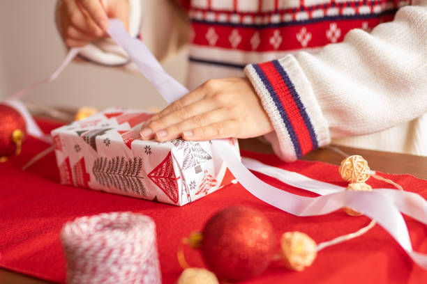 istock Christmas mood. Women's hands pack gifts at home 1284774875