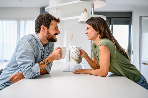 Shot of a young couple having coffee together in the kitchen at home