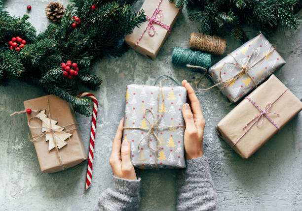 Top view of hands holding Christmas gift boxes.