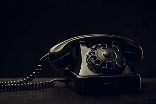 Black retro telephone in dark room