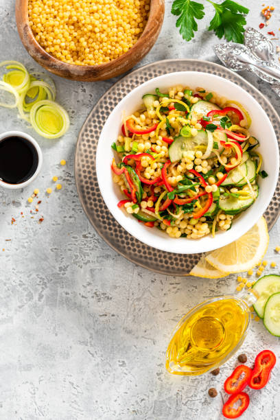 istock Vegetable salad with ptitim in a white bowl on a gray background top view 1284777178