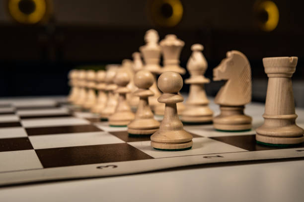 istock Play old chess tree on a platform in a white cage, black pieces and rooks, queens and kings, horses table in the dark, stylish for advertising design. 1284778606