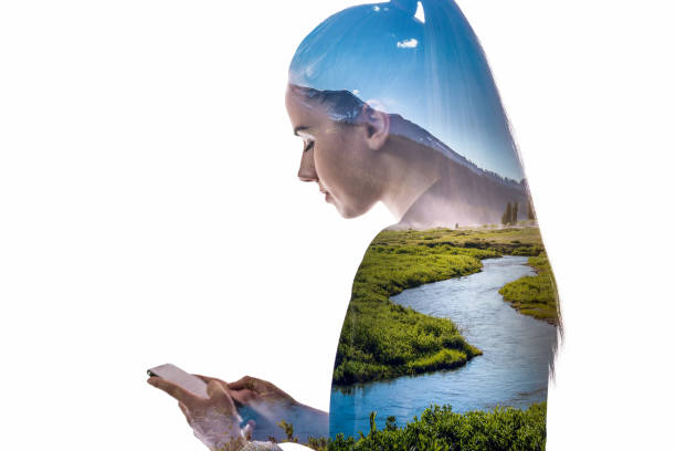 Double exposure of young woman using smartphone and landscape with meandering river
