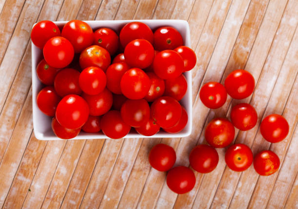 istock ripe cherry tomate in white plate on wooden table 1284778870
