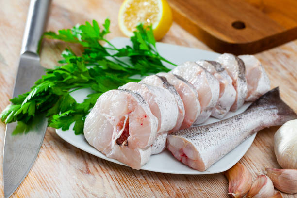 piezas de merluza fresca con condimentos preparados para cocinar - merluza fotografías e imágenes de stock