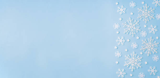 istock Flat lay christmas border with snowflakes on a blue background 1284778989