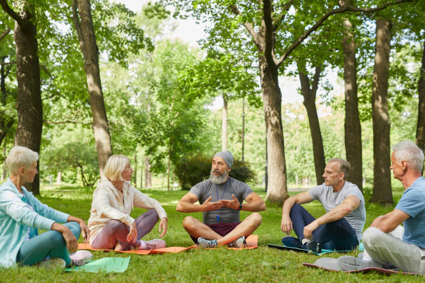 istock Senior People Practicing Yoga In Park 1284779106
