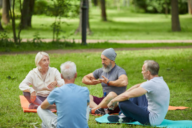 istock Seniors Practicing Yoga In Park 1284779216