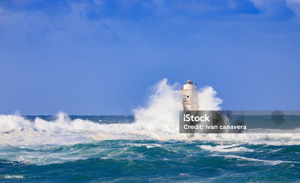 lighthouse of the mangiabarche of calasetta in a stormy day, sardinia Atmospheric Mood Stock Photo