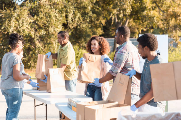 istock Multi-ethnic group stands in row to fill food bags 1284781168