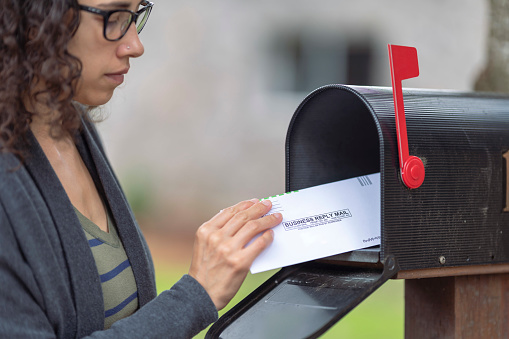 woman looking at letter in mailbox