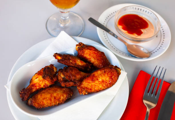 istock Appetizing baked chicken wings in plate closeup 1284781632
