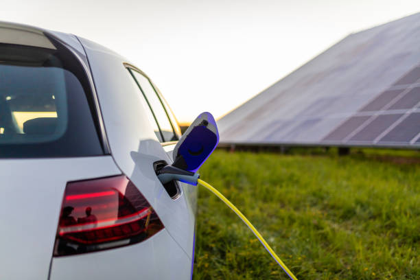 samochód elektryczny jest podłączony do ładowania z panelami słonecznymi w tle - car stationary blue sky zdjęcia i obrazy z banku zdjęć