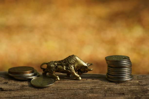 istock Metal bull figurine with coins close-up. 1284782413