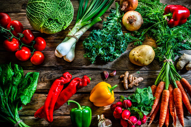 istock Healthy food backgrounds: fresh multicolored vegetables on rustic table. 1284782568