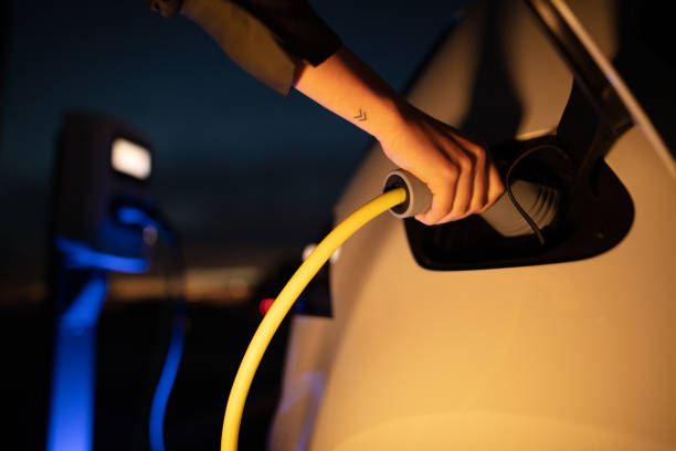 istock Woman plugging a charger into electric car 1284782968
