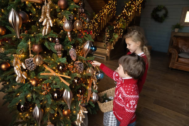 istock Little kids have fun decorating Christmas tree at home 1284784033